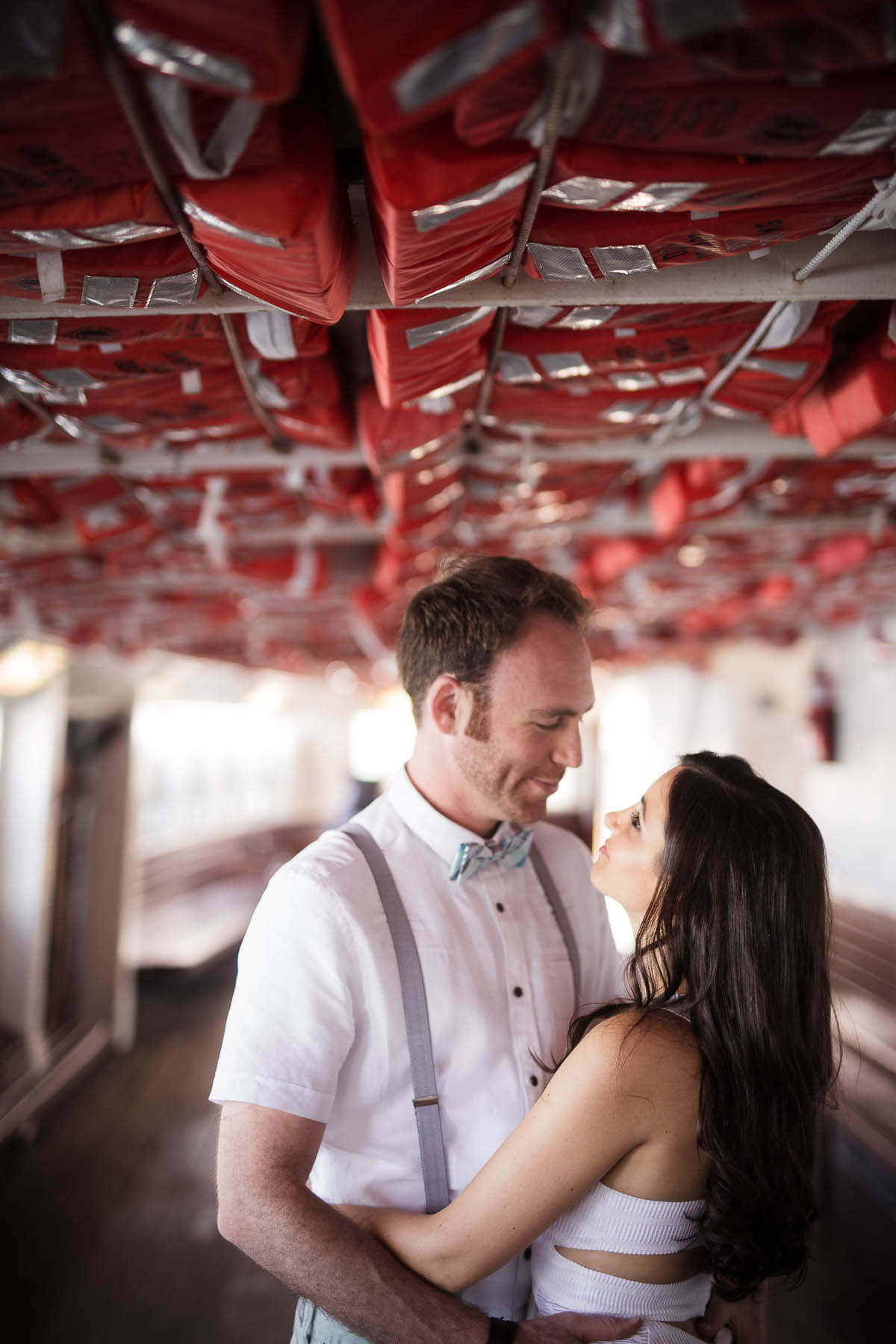 Toronto Island inside a boat engagement session with couple looking into each other's eyes