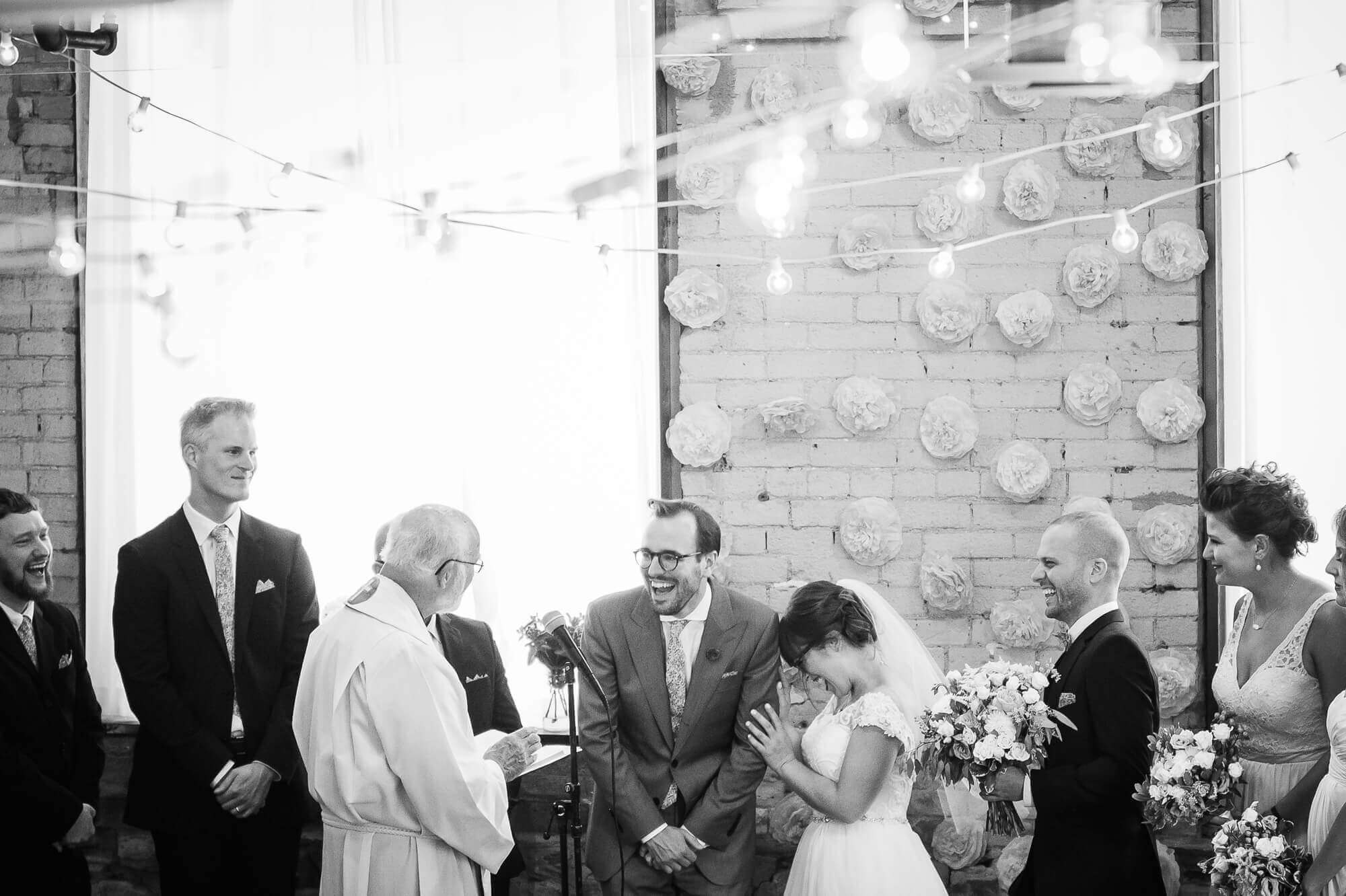 Black and white portrait of the bride and groom laughing during their boho ceremony at Hotel Ocho, Toronto