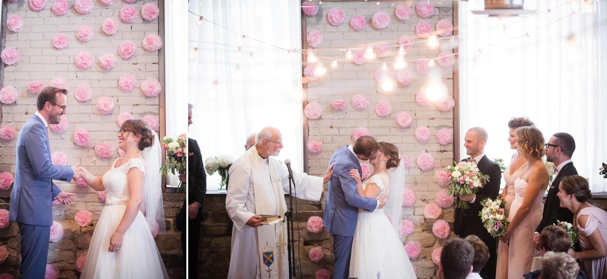 Beautiful portrait of the bride and groom kissing in front of their DIY flower alter at Hotel Ocho, Toronto