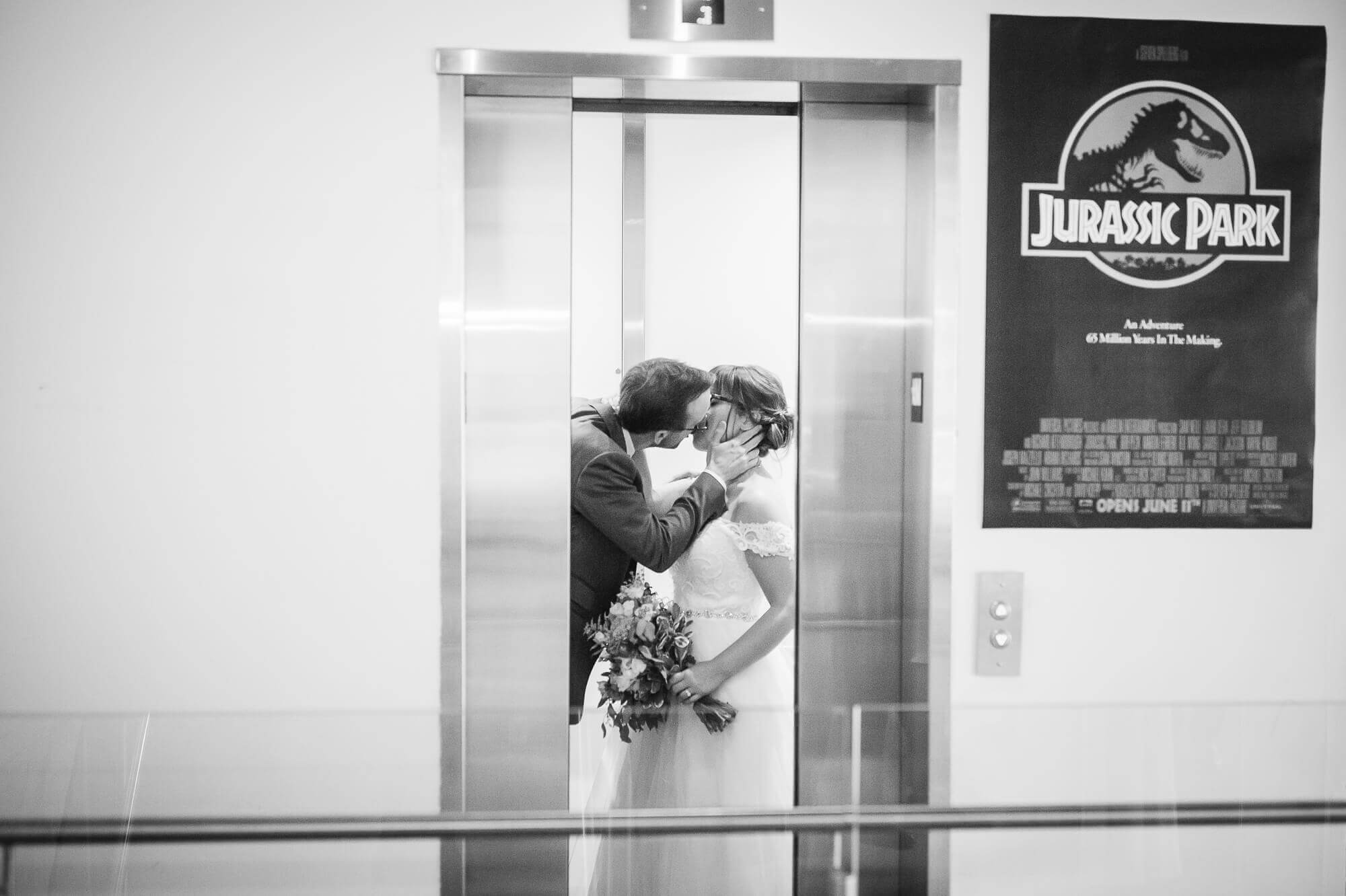 Black and white portrait of the bride and groom caught kissing as the elevator doors close at Hotel Ocho, Toronto