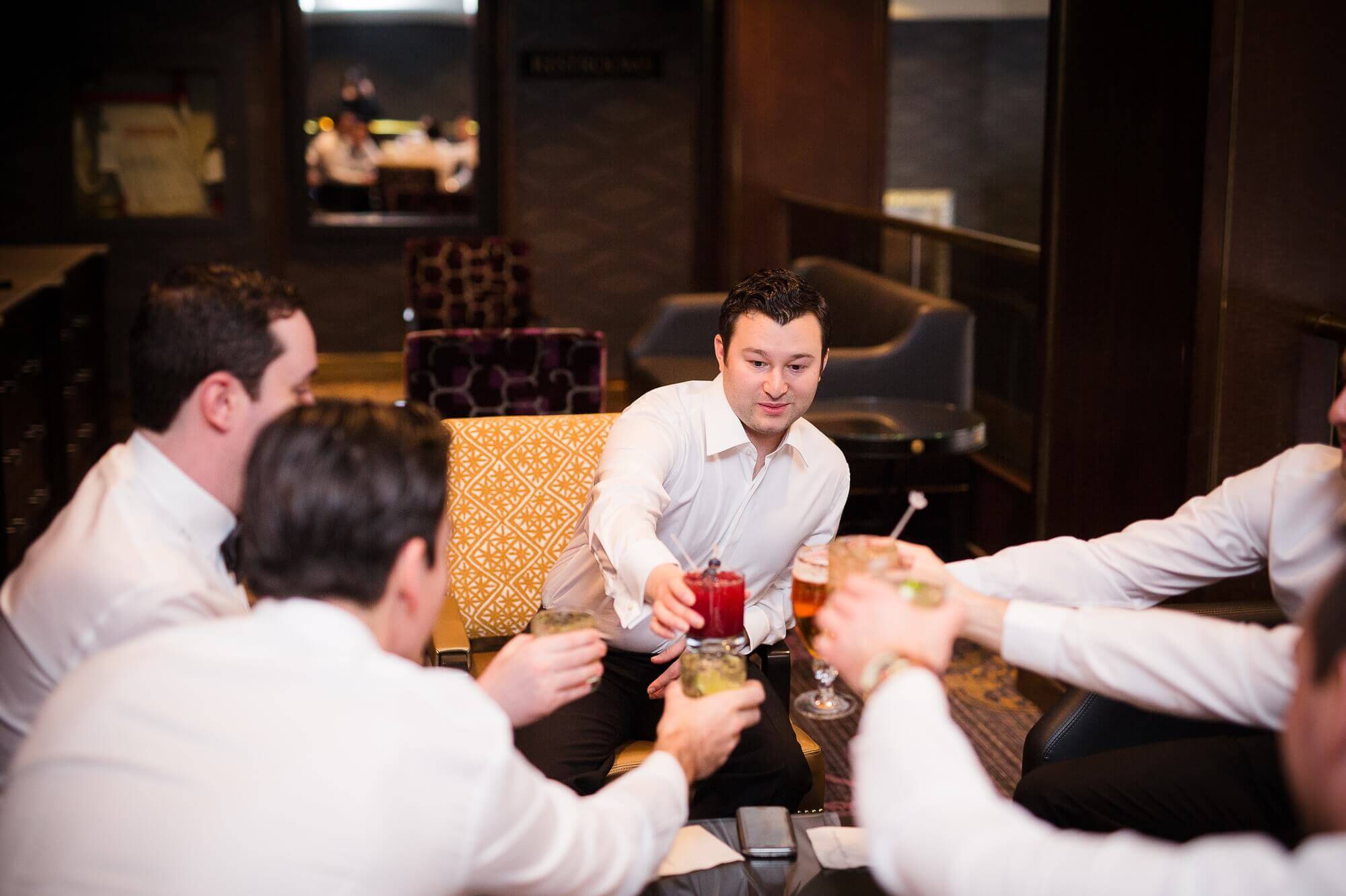 Portrait of the groom and his groomsmen cheersing before the ceremony in the Omni King Edward Hotel in Toronto