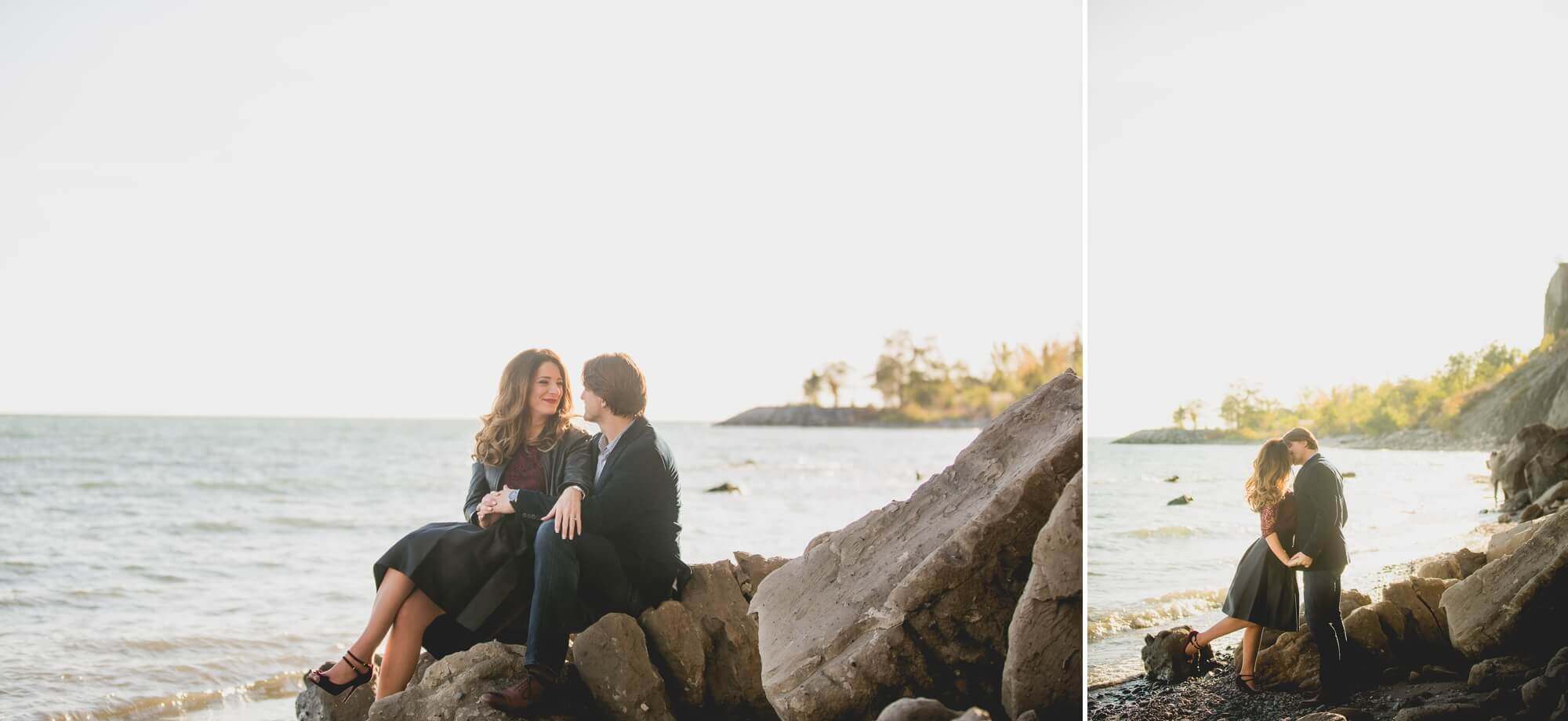 The couple sits on rocks at Scarborough Bluffs engagement shoot in Toronto