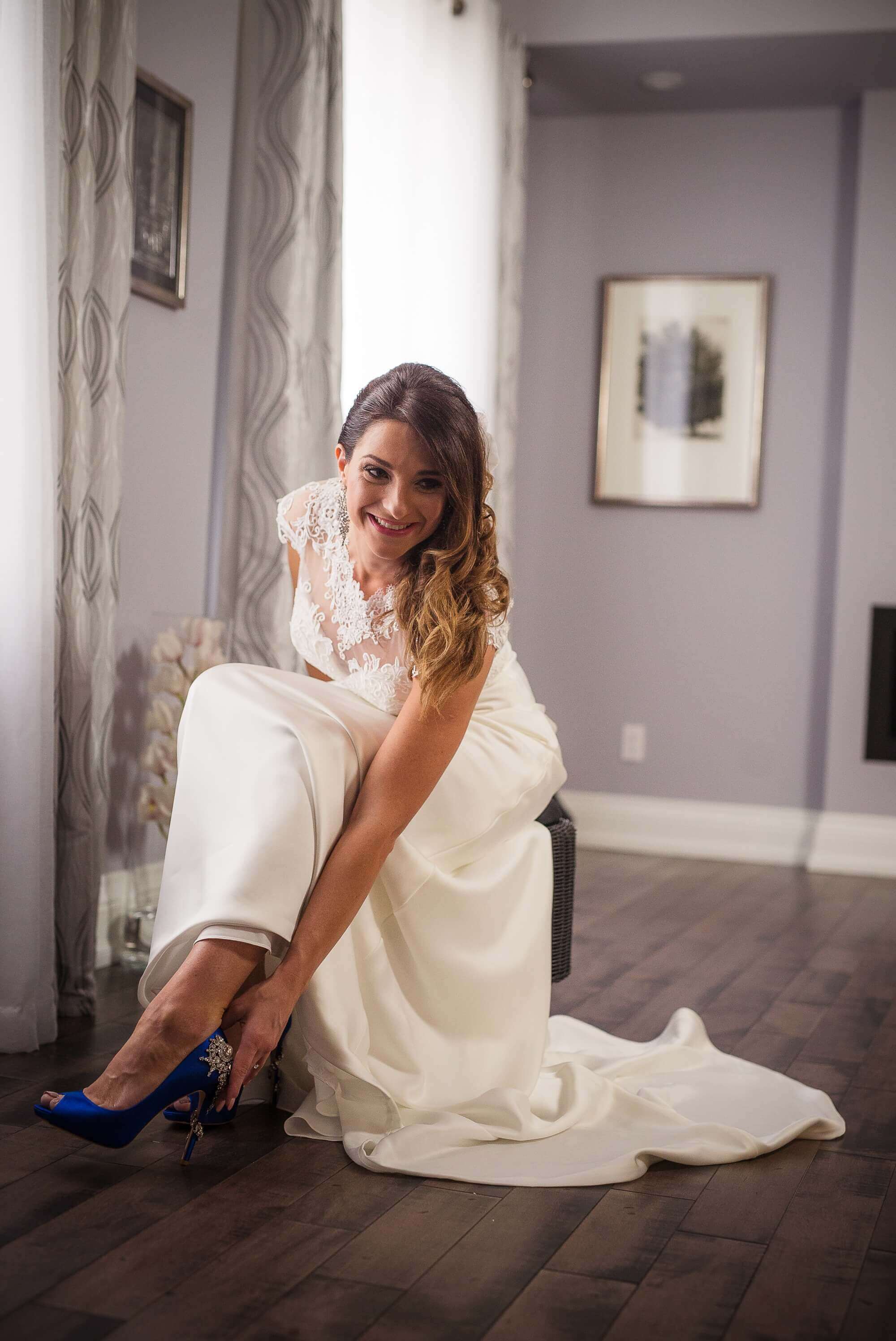 Portrait of the bride putting on her beautiful blue heels