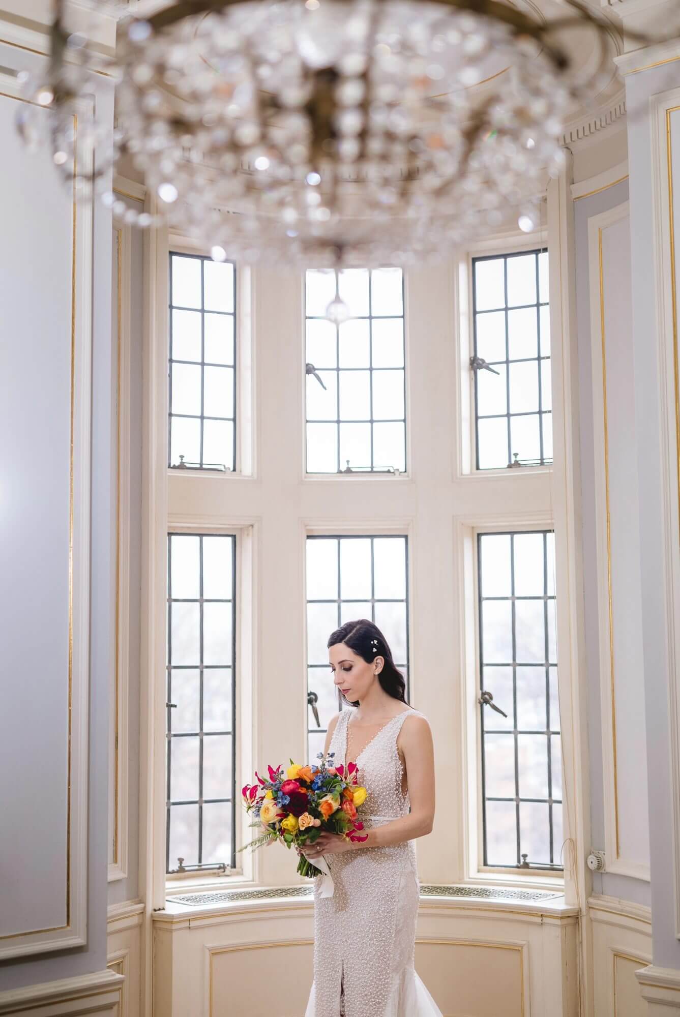 Portrait of the bride underneath a beautiful chandelier at Casa Loma in Toronto